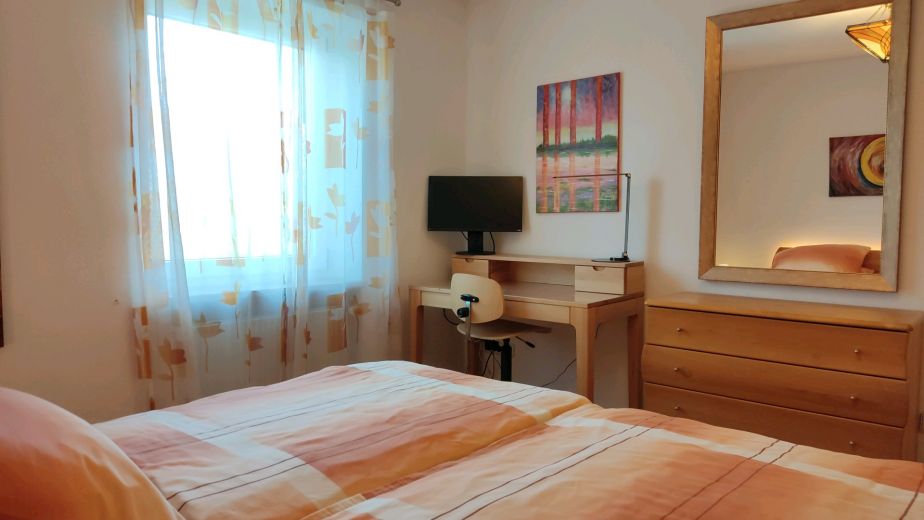 Schlafzimmer mit Spiegel, Kommode und Sekretär