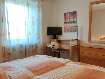 Schlafzimmer mit Spiegel, Kommode und Sekretär